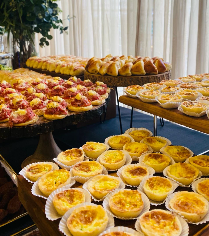 Mesa de brunch corporativo com quiches, tortas e salgados finos para eventos empresariais