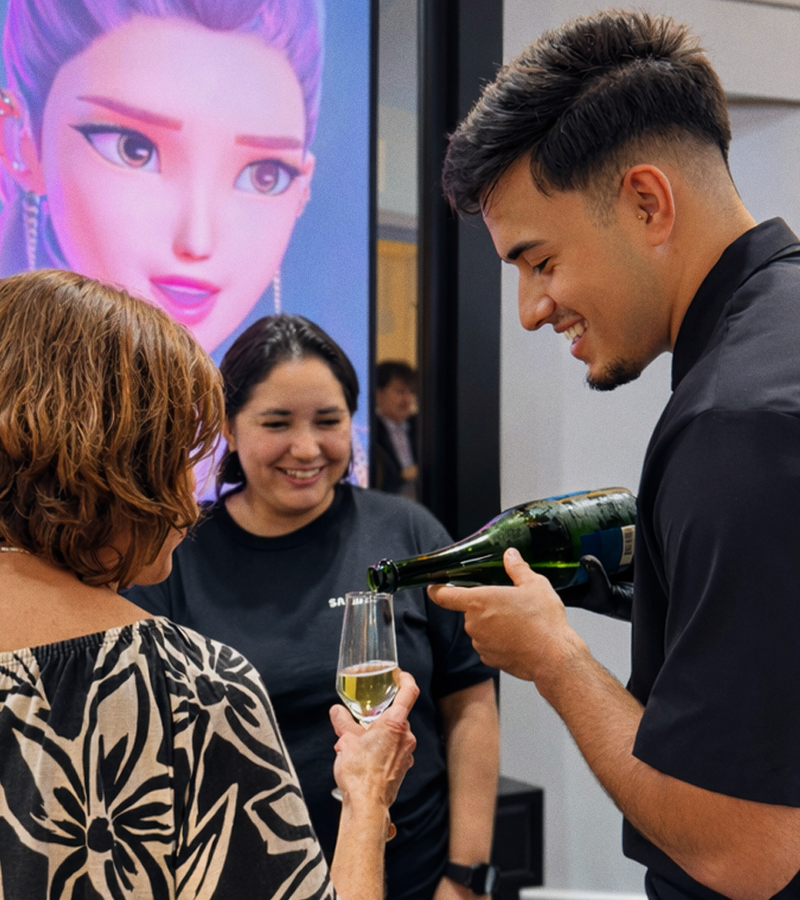 Serviço de coquetel corporativo com garçom servindo bebidas em evento empresarial